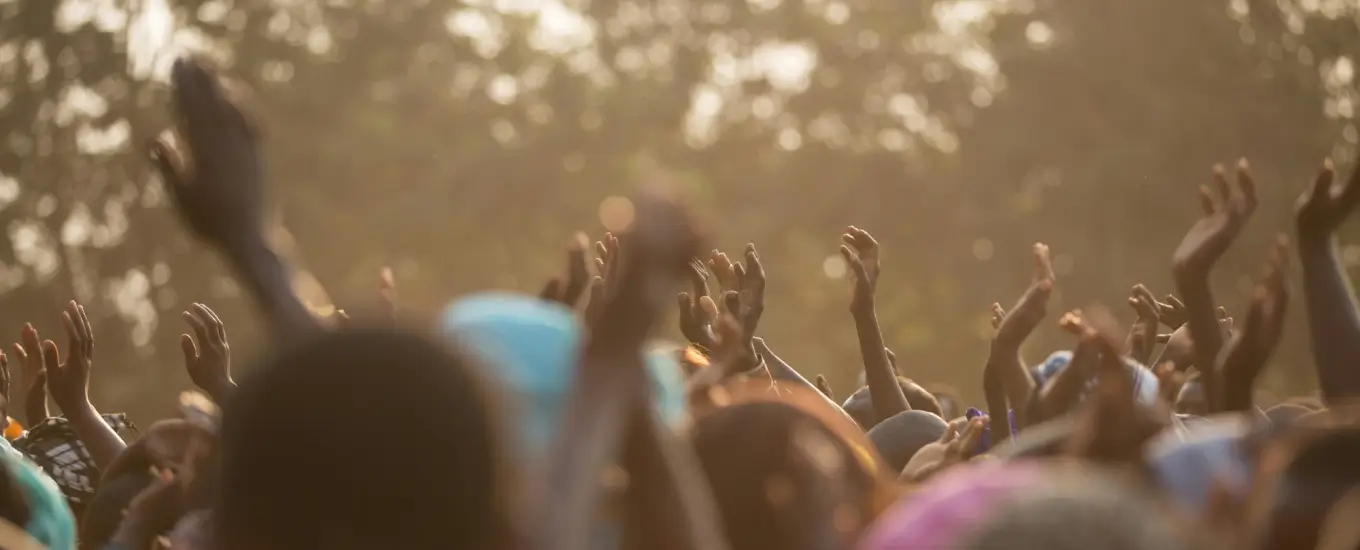 Community members celebrating collaborative governance success in conflict-affected region